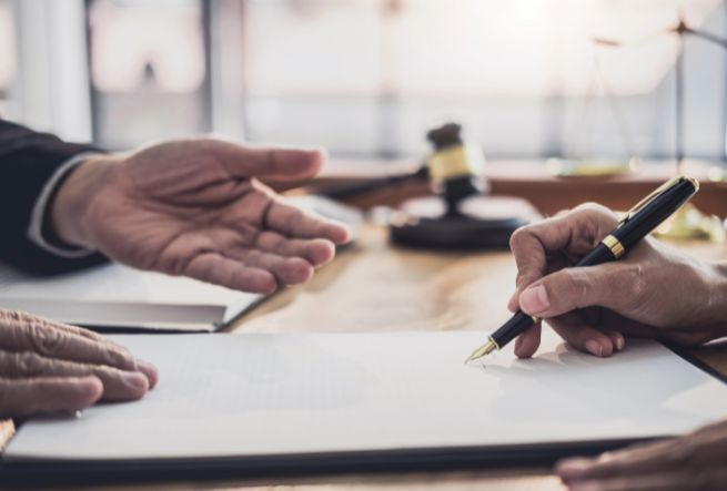 Business owners signing a General Liability Insurance policy at an office in the Woodlands, TX