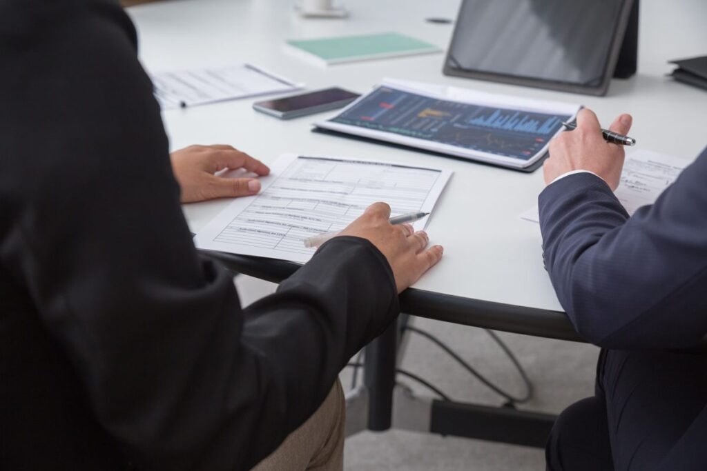 Employer and insurance agent reviewing group health insurance premiums and renewal paperwork
