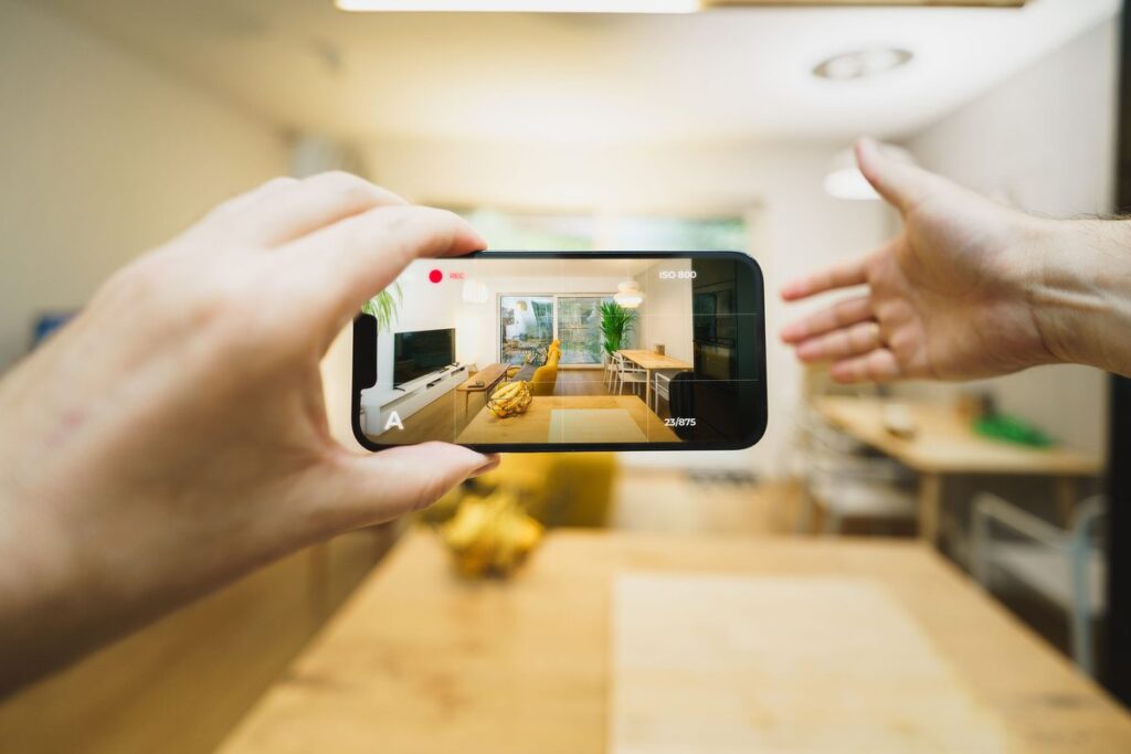 Homeowner recording a home inventory video of their living room with a smartphone
