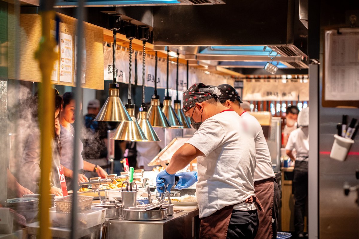 Restaurant insurance Dallas: cooks plating orders on a busy kitchen line