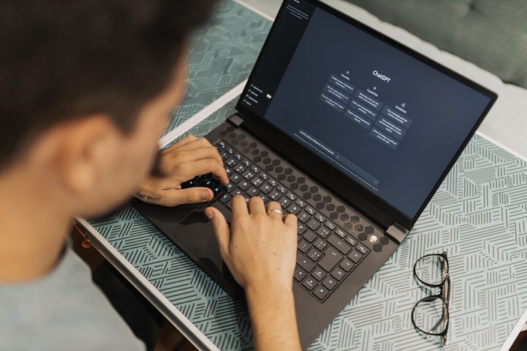 Person typing on a laptop, learning to use AI to understand insurance